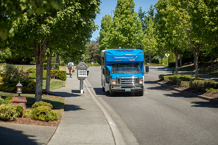 Community Transit shuttle driving in a neighborhood.